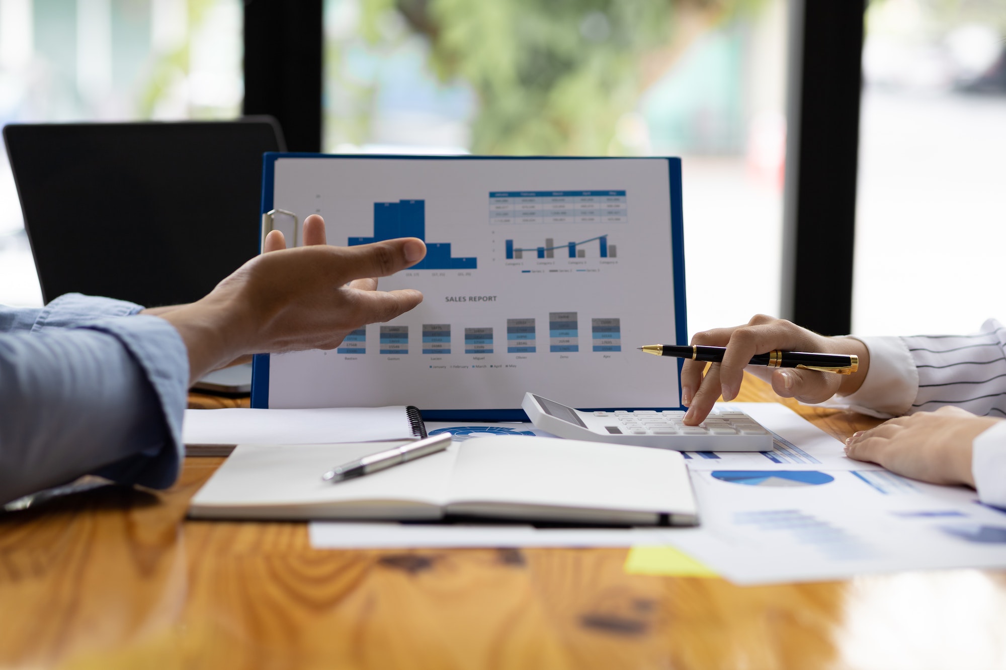 Business finance consultants discuss analysis of marketing reports profitability of the business.